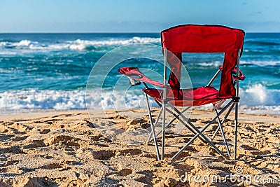 A red beach chair facing the water on Sunset Beach, Hawaii Stock Photo