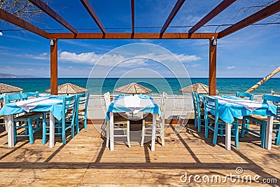 Empty restaurant tables at the Maleme beach on Crete, Greece Stock Photo