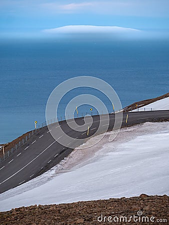 an empty road goes down to the coast on a clear day Stock Photo