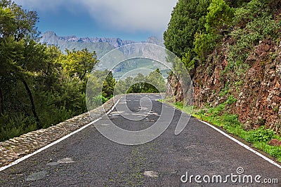 Empty road on the mountains with a cloudy blue sky. Landscape of a countryside roadway for traveling on a mountain pass Stock Photo