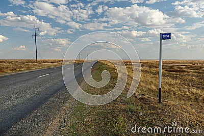 Empty road in the steppe and kilometer sign 1001 Stock Photo