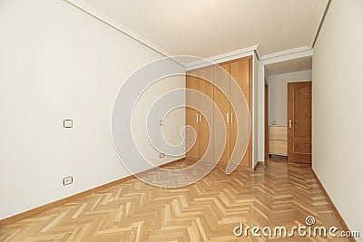 Empty room with a built-in wardrobe with four folding oak doors Stock Photo