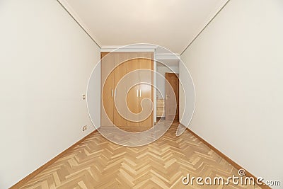 Empty room with built-in wardrobe with four oak folding doors Stock Photo