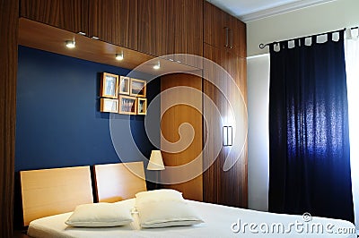 Empty Bed Room with Dark Navy Blue Wall and Wooden Wardrobe Stock Photo