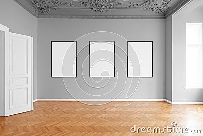 Empty room with three blank picture frames hanging on wall in apartment Stock Photo