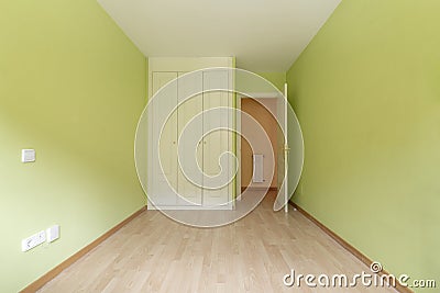 Empty room with white wooden three-section built-in wardrobe, green Stock Photo