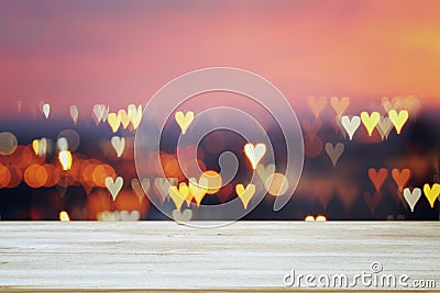 Empty rustic table in front of Valentine& x27;s day romantic glitter bokeh background with many hearts lights Stock Photo