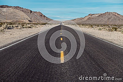 Empty scenic long straight desert road with yellow marking lines. Stock Photo