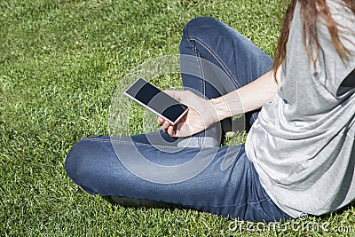 Empty screen phone woman on grass Stock Photo