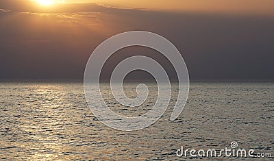 Empty sea to the horizon, evening. The sun is approaching the horizon, a light path is visible on the water. Stock Photo