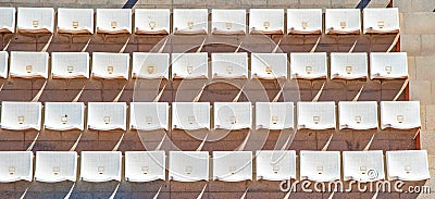 Empty plastic seat on tribune of the stadium cast a shadow on the concrete Stock Photo