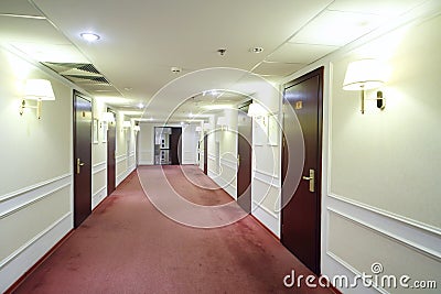 Empty simple light hallway with many wooden doors Stock Photo