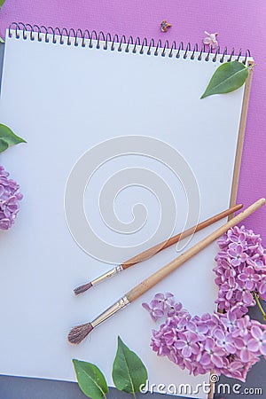 Empty space album list with lilac bunch of flowers and paint brushe Stock Photo