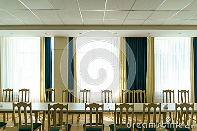 An empty spacious banquet hall with tables and chairs and panoramic windows. Preparing a restaurant for a wedding dinner, Stock Photo