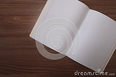 An empty squared notebook on a brown wooden table Stock Photo