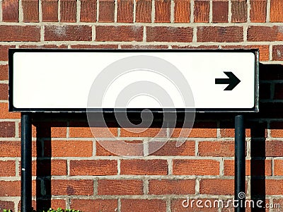 Empty street direction sign against a brick wall Stock Photo