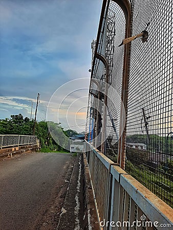 an empty street was bridged with an iron fence on its side Stock Photo