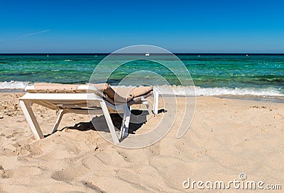 Empty sunbed in front of turquoise water Stock Photo