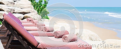 Empty sunbed with wrapped towels on a beautiful beach Stock Photo