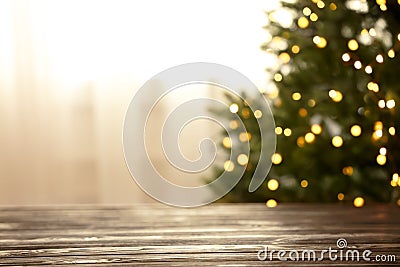 Empty table and blurred fir tree with yellow Christmas lights on background, bokeh effect Stock Photo