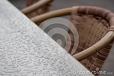 Empty table and empty chairs of summer restaurant or beer garden in summer on rainy day with raindrops and no guests, no income on Stock Photo