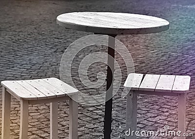 An empty table and two stools in front of restaurant Stock Photo