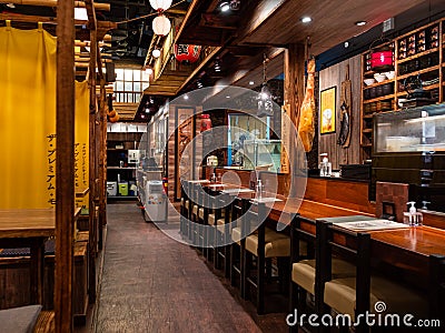 Empty tables with no customers at The Public Izakaya Japanese restaurant in Tanjong Pagar, Singapore in the evening. Business has Editorial Stock Photo