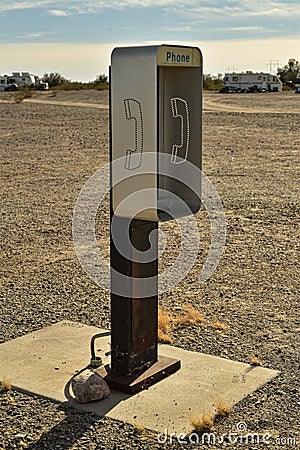 Empty telephone booth in desert outdated technology Stock Photo