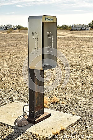 Empty telephone booth in desert outdated technology Stock Photo