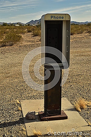 Empty telephone booth in desert outdated technology Stock Photo