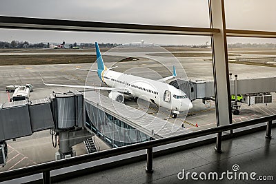 Empty terminal, aircrafts are waiting and preparing for their next flight and one of them taken off Editorial Stock Photo