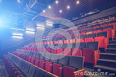 Empty theatre or cinema auditorium hall with rows of seats or chairs with blue spotlights or screen light effect Stock Photo