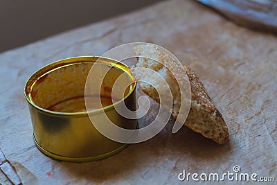 An empty tin can with the remains of tomato sauce with a slice of flat bread as a symbol of need and insufficient Stock Photo