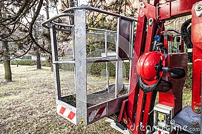 An empty tracked basket for gardeners with helmet. Mobile aerial work platform Stock Photo