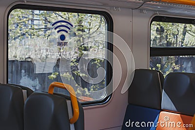 Empty train carriage with multicolored seats and a sticker on the window WI-FI Stock Photo