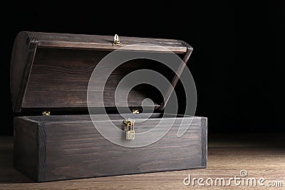 Empty treasure chest on table against black background Stock Photo