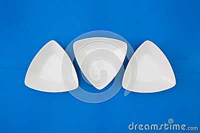 Empty triangular ceramic bowls for sushi on the blue wooden table Stock Photo