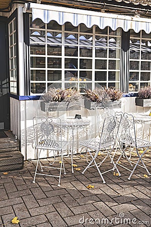 Vintage wrought iron garden table and chairs in public cafe in an autumnal garden Editorial Stock Photo