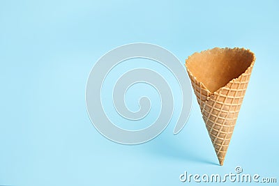 Empty wafer ice cream cone on blue background. Space for Stock Photo