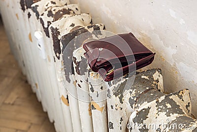 Empty wallet on an old shabby radiator, Concept Living in poverty, Rising energy prices, Social inequality, Inflation affecting Stock Photo