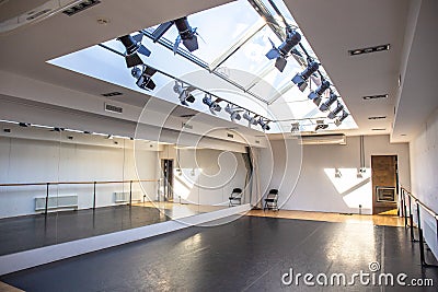 Empty white dance studio or hall for activities or yoga room with mirror wall and windows in celling Stock Photo