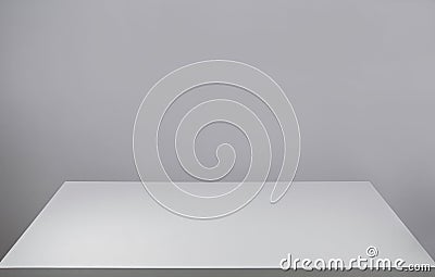 Empty white desk table and a blank grey wall for copy space. Graphic resource for design. Front view minimalist workspace. Board Stock Photo