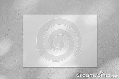 Empty white horizontal rectangle poster mockup with diagonal window shadow on the wall Stock Photo