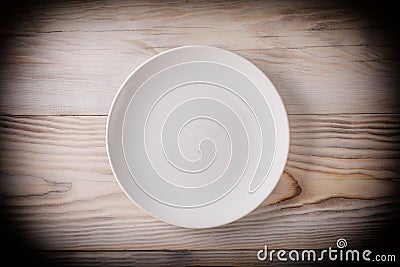 Empty white plate on wooden table with vignette. Top view Stock Photo
