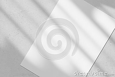 Empty white vertical rectangle poster mockup with diagonal window shadow on the wall Stock Photo