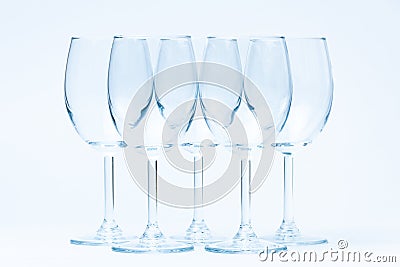 Empty wine glasses stand symmetrically on white Stock Photo