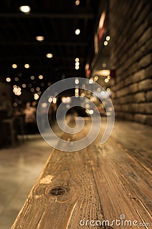 Empty wood table top of bar with blur of cafe restaurant in dark Stock Photo