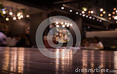 Empty wood table top on blur cafe restaurant in dark night with light background/selective focus Stock Photo