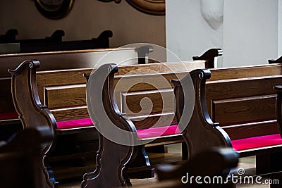 Empty wooden benches in Catholic Church Stock Photo