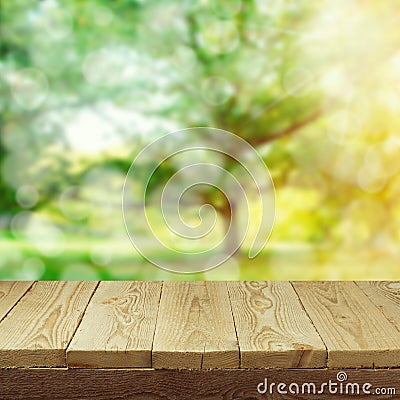 Empty wooden deck table with foliage bokeh background for product display montage. Spring or summer Stock Photo